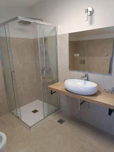 a bathroom with a glass shower and a sink at House in Istria in Plomin