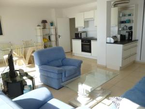 uma sala de estar com uma cadeira azul e uma cozinha em Appartement La Baule, 3 pièces, 4 personnes - FR-1-245-113 em La Baule