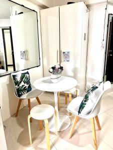 una mesa y sillas con un jarrón en una habitación en BURNHAM HILL CONDOMINIUM, en Baguio