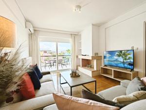 a living room with a couch and a tv at Menelaou by Verde Apartments in Athens