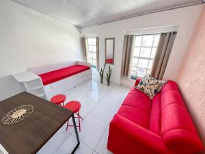 un soggiorno con divano rosso e tavolo di São Francisco Aparts a Salvador