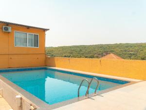 a swimming pool on the side of a building at Red Button Resort & Go-Karting in Mahabaleshwar