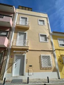 - un bâtiment jaune avec une porte et un balcon dans l'établissement Sunny, The House - AL, à Faro