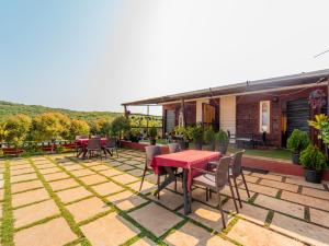 a patio with a red table and chairs at Red Button Resort in Mahabaleshwar