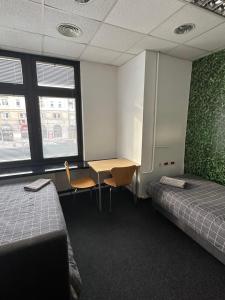 a room with two beds and a desk and two windows at Aleja "Solidarności" in Warsaw