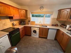 a kitchen with wooden cabinets and a washing machine at Spacious Luxurious Serviced Accommodation 3 in Warmsworth
