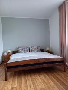 a bed in a bedroom with a wooden floor at Apartamenty AGAT in Pieszyce