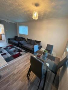 ein Wohnzimmer mit einem Sofa und einem Tisch in der Unterkunft Spacious Luxurious Serviced Accommodation 3 in Warmsworth