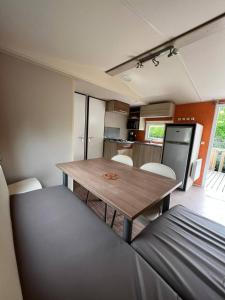 eine kleine Küche und ein Esszimmer mit einem Tisch und Stühlen in der Unterkunft Mobil Home Cosi pour 6 (Camping Tohapi) in Vogelgrun