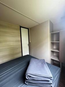 a room with a bed with a door and a closet at Mobil Home Cosi Climatisé pour 6 - Camping Tohapi in Vogelgrun +4 photos