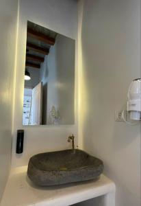 ein Steinwaschbecken in einem Badezimmer mit Spiegel in der Unterkunft Psathi in Kythnos