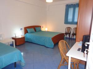 a bedroom with a bed and a table and chairs at Un Tuffo alla Scala dei Turchi in Realmonte
