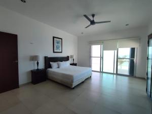 a bedroom with a bed and a ceiling fan at Casa Chelem in Chelem
