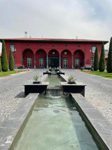 a red building with a fountain in front of it at Аль-Фараби-Ходжанова. Вид на горы. ЖК Оркен in Almaty