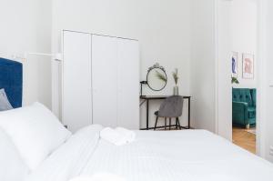 a white bedroom with a white bed and a chair at Brand Cozy Apartment in Vienna