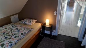 een slaapkamer met een bed en een lamp op een nachtkastje bij Guesthouse Gärsnäs in Gärsnäs