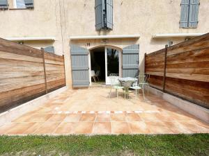 une terrasse avec une table et des chaises devant un bâtiment dans l'établissement Appartement 11 en duplex - LES SUITES DE ROBINSON - Résidence avec piscine en bord de Siagne, à Mandelieu-La-Napoule, à Mandelieu-la-Napoule