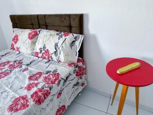 a bed with a red stool next to a red table at São Francisco Aparts in Salvador
