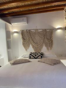 ein Schlafzimmer mit einem weißen Bett und einem darüber hängenden Vorhang in der Unterkunft Psathi in Kythnos