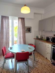 une cuisine avec une table, des chaises rouges et une table dans l'établissement Ulysses Apartments Acropolis, à Athènes