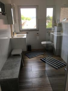 La salle de bains est pourvue d'un lavabo, de toilettes et d'une fenêtre. dans l'établissement Gästehaus Eichwald, à Neuenbürg