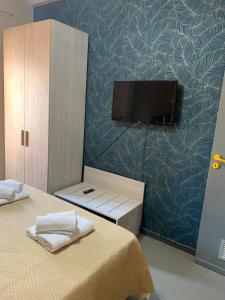 una camera con TV a parete e un letto di lacasettadinoel a Lampedusa