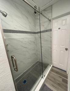 um chuveiro com uma porta de vidro na casa de banho em The Blue Wave Suite Unit B em St. Petersburg