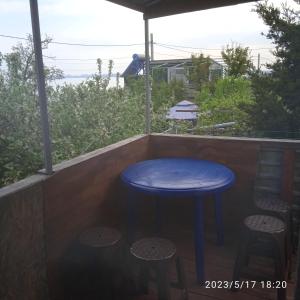 a blue stool sitting on a balcony with two stools at Мансарда in Fontanka