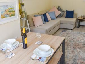 ein Wohnzimmer mit einem Tisch und einer Flasche Wein in der Unterkunft Rookmead Cottage in Yarmouth