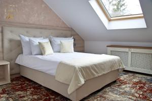 a bedroom with a bed with white sheets and a window at Hotel Anda in Sinaia