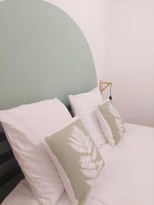 ein Bett mit vier weißen Kissen darauf in der Unterkunft °Appart' 1 Audincourt centre ° in Audincourt