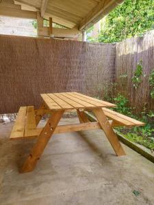 einem Picknicktisch aus Holz vor einem Zaun in der Unterkunft °Appart' 1 Audincourt centre ° in Audincourt
