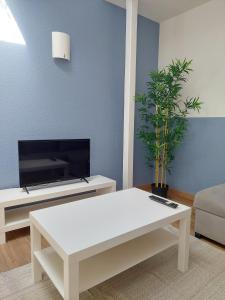 ein Wohnzimmer mit einem weißen Couchtisch und einem TV in der Unterkunft °Appart' 1 Audincourt centre ° in Audincourt
