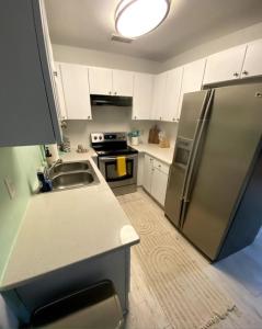 a kitchen with a stainless steel refrigerator and white cabinets at Colorful home St Petersburg in St Petersburg