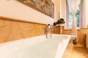 Klimt - Jacuzzi 5 Star - Luxury Design Apartment في ميلانو: حوض استحمام مع صنبور في الحمام