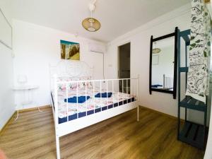 - un lit bébé blanc dans une chambre avec miroir dans l'établissement OZ Vama Veche, à Vama Veche