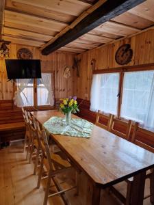 een eettafel met een vaas met bloemen erop bij OTO`S CABIN in Radovljica