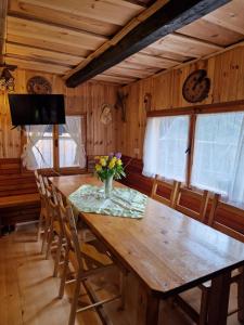 a dining room table with a vase of flowers on it at OTO`S CABIN in Radovljica