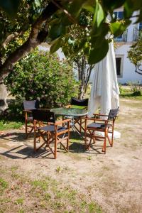 uma mesa e cadeiras com um guarda-sol branco e uma mesa e cadeiras sidx sidx sidx em Palácio da Quinta da Portela II em Coimbra