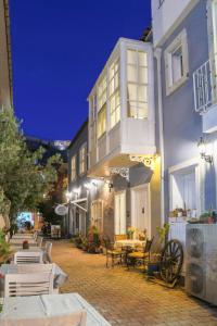 a building with a balcony and tables and chairs at Dantela Butik Hotel in Çeşme