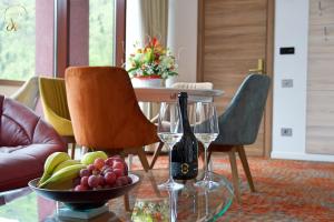 un tavolo con due bicchieri di vino e un cesto di frutta di Hotel Anda a Sinaia
