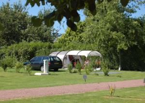 un coche aparcado en un jardín con una tienda de campaña en Les Insolites du vélodrome d'Albert en Albert