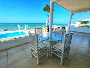 a table and chairs on a balcony overlooking the ocean at Casa Chelem in Chelem