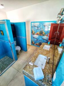 a bathroom with two sinks and a fish painting on the wall at Casa Chelem in Chelem