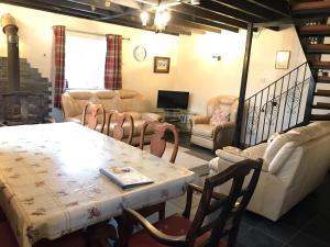 a living room with a table and chairs and a couch at Cottage on Exmoor - Sleeps 8 & Parking in Minehead