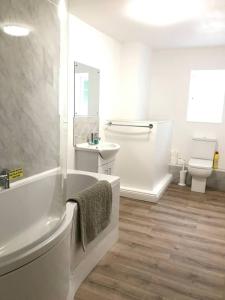 a bathroom with a tub and a sink and a toilet at Charming 3-Bed House on Exmoor in Minehead
