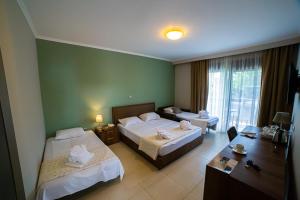 a hotel room with two beds and a desk at Vellum Luxury Living in Kallithea Halkidikis +117 photos