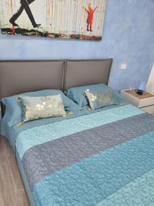 Una cama con sábanas azules y almohadas en un dormitorio en B&B DIANA, en Pordenone