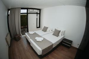 um quarto com uma cama grande e uma janela em Ovis Hotel Apartments em Agia Napa