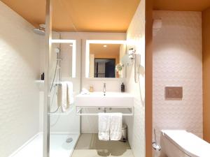 德莱蒙Mercure Hotel Delémont的带水槽和淋浴的浴室
